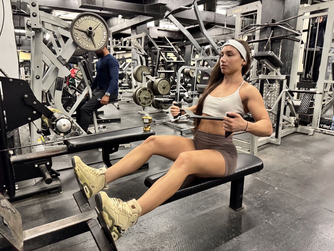 london-fitness-girl-trains-upper-body-in-a-busy-gym